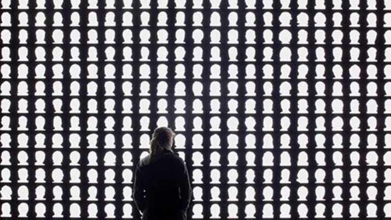 A woman looking at a wall of silhouettes