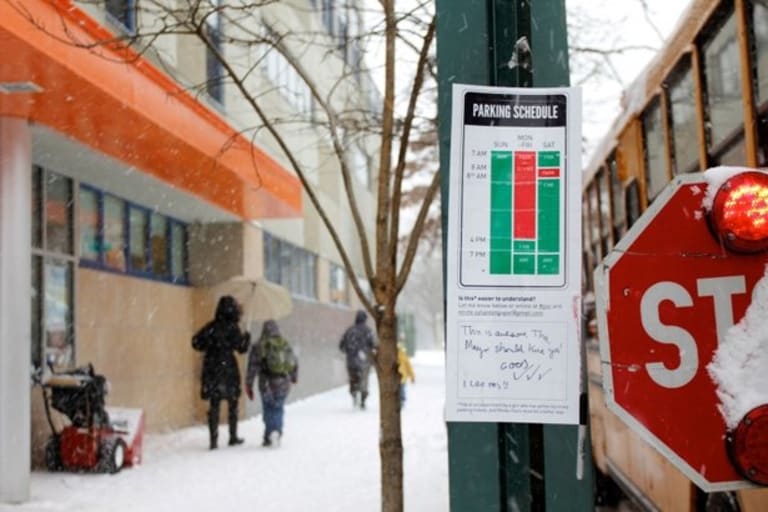 Parking schedule sign on a snowy day
