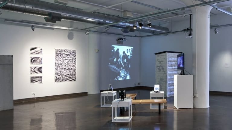 A white room with a projection arrangement and art on the wall