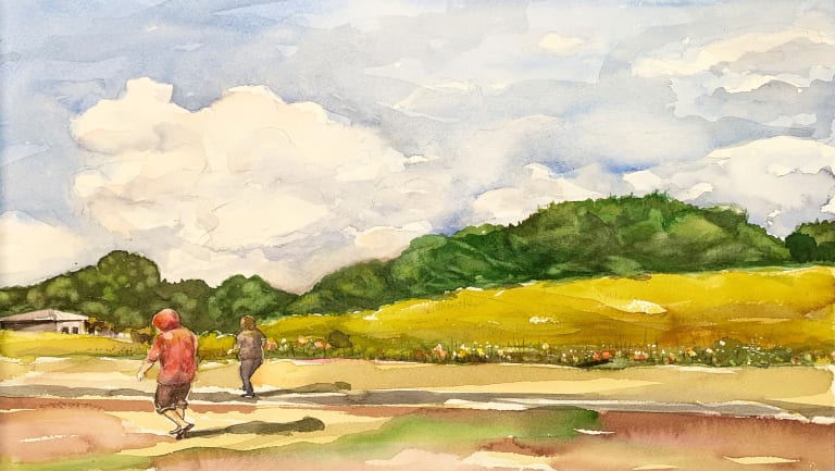 Watercolor image of two people in a field with mountains in the background. The sky is blue with puffy clouds. 