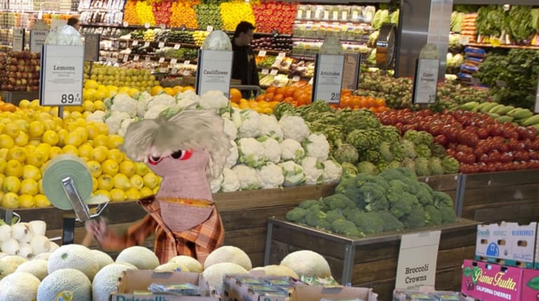 A puppet inside a produce area in a grocery store.