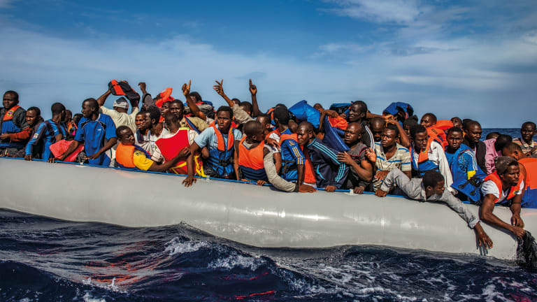One hundred and nine African refugees from Gambia, Mali, Senegal, Ivory Coast, Guinea, and Nigeria are rescued by the Italian navy from a rubber boat in the sea between Italy and Libya, October 2014.
