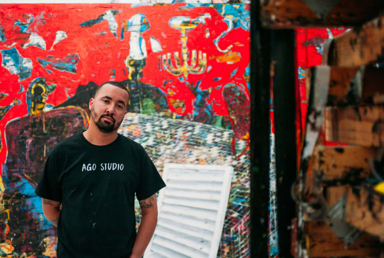 Image of Angel Otero in front of large red artwork 