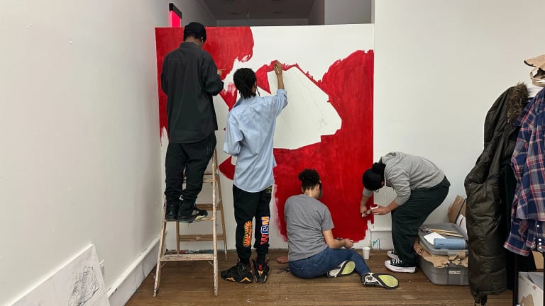 a group of four volunteers working on a wall the "Jah" wall mural