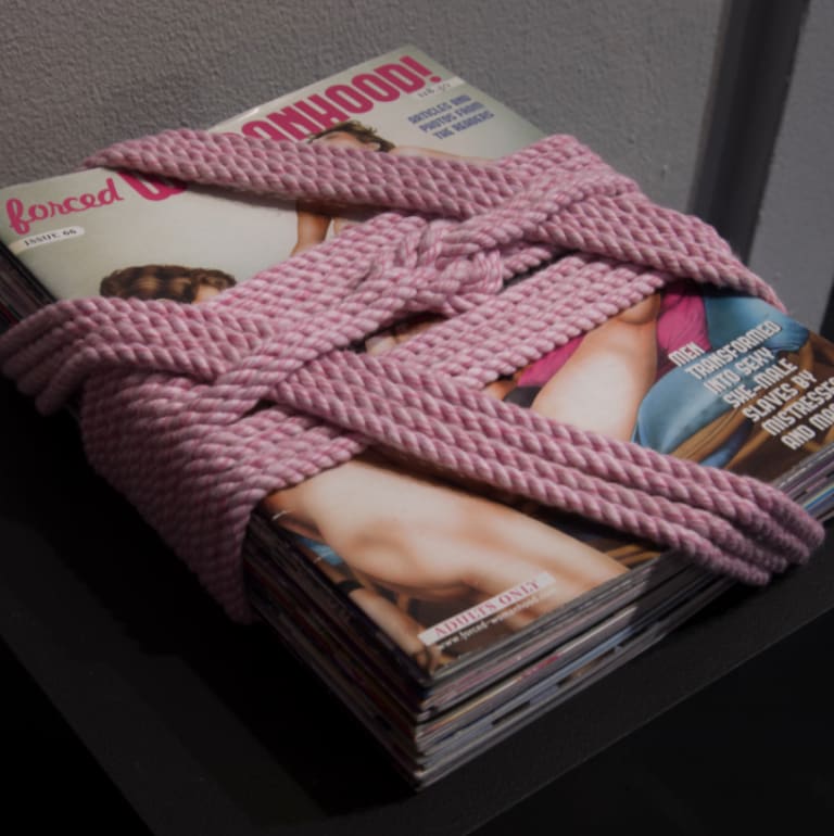 a pile of magazines wrapped up in pink rope