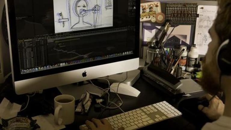 A man reviewing a simple drawing on a computer as he sits at his desk