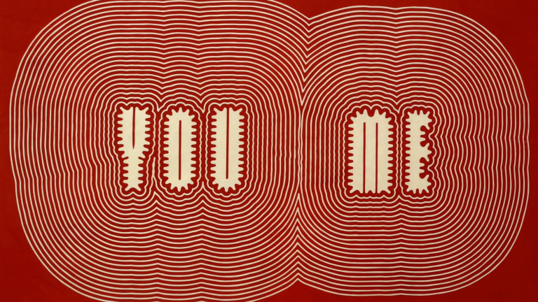 Stylized text artwork by Paula Scher in red and beige, "You Me," designed with a 'reverberating'-type effect around each word.