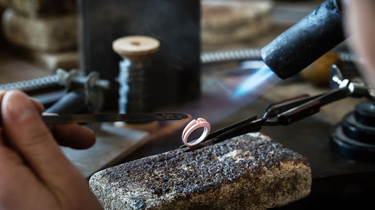 person heating a ring in a jewelry workstation