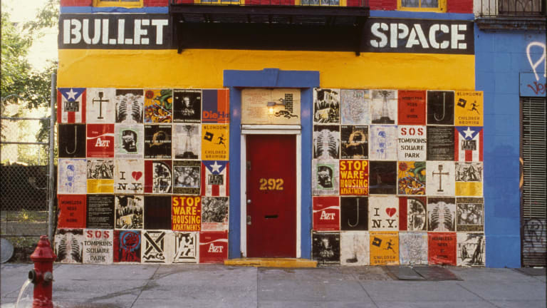 Here is the facade of Bullet Space, painted in primary colors of red, blue, yellow, and featuring a grid of graphic design and artwork about social change.