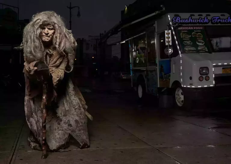photo of old woman with long unruly grey hair in an animal-skin robe, leaning on a gnarled walking stick, with a taco truck in the background