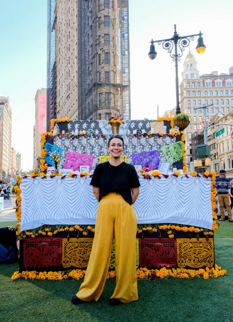 Artist Paulina Mendoza Valdez in front of the Dia de Muertos altar in Flatiron Plaza.