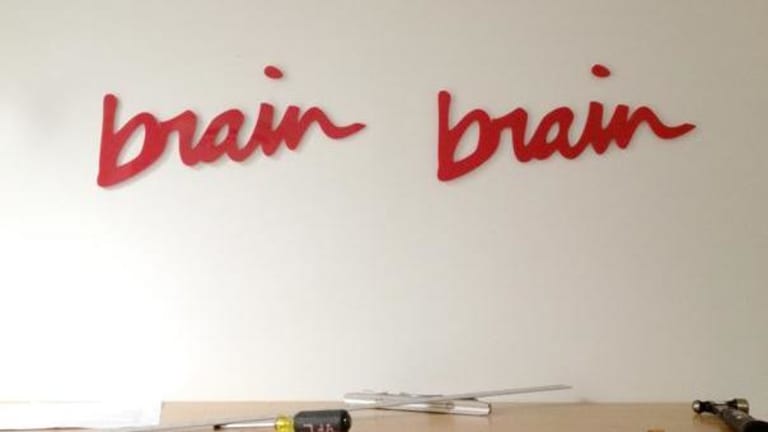 Brain Brain written on a while wall above tools.