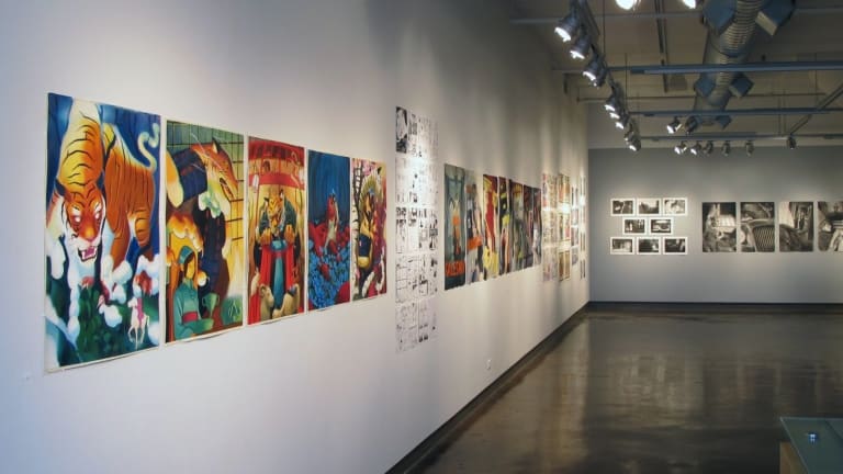 Gallery space with colorful modern art and black and white photography mounted on walls