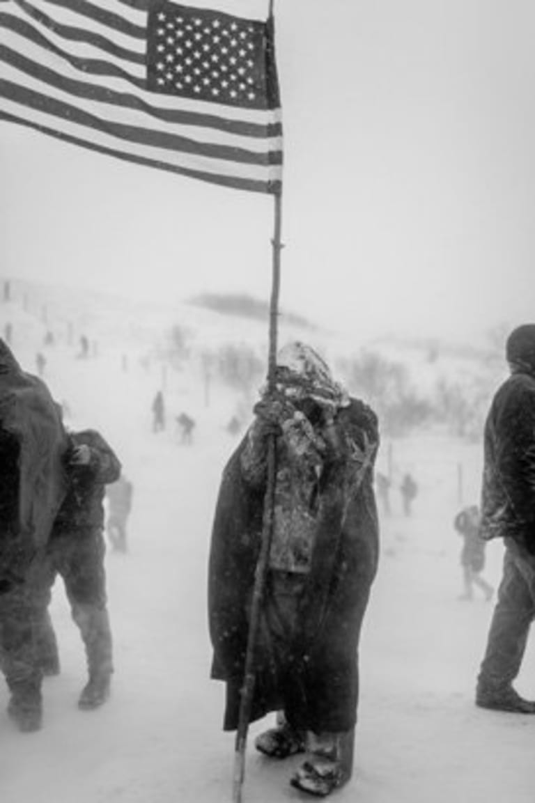 An image of a person holding a stick with a flag attached to it.