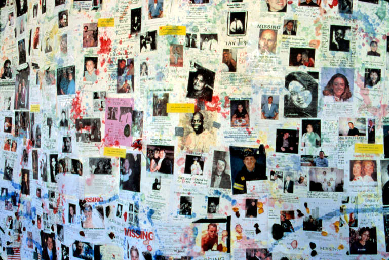 Photo of a wall plastered with photos and announcements of missing persons following the terrorist attacks of 9/11/2001.