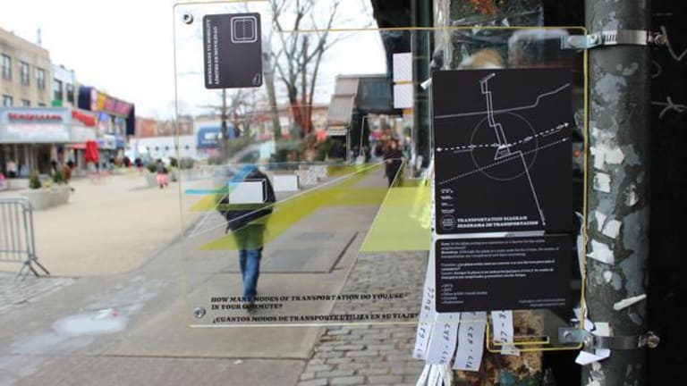 Is a picture of several people walking on the sidewalk in the city, the closest for you looks like a map of downtown city streets and possible store locations on the map. Attached to a message board with random paper with numbers on them.