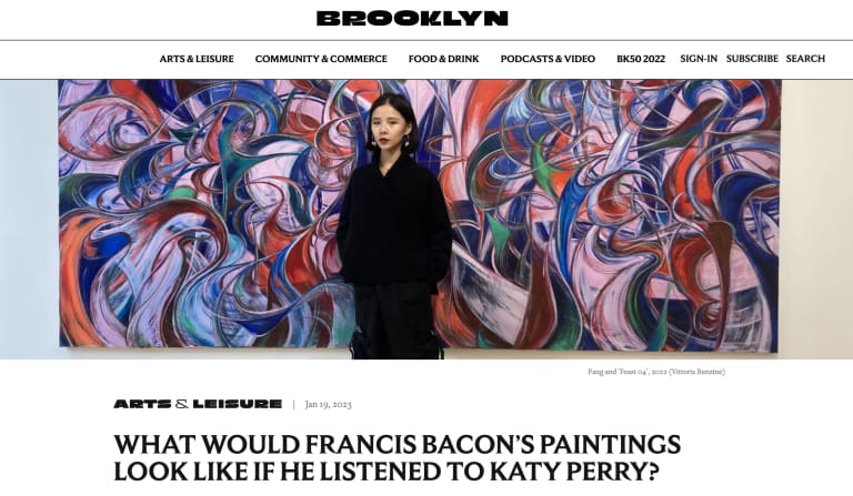 A screen short from a Brooklyn Magazine article showing the title and a photo of a woman in a long black coat, standing in front of one of her abstract paintings of curving entangled forms in blue, red, pink, and green