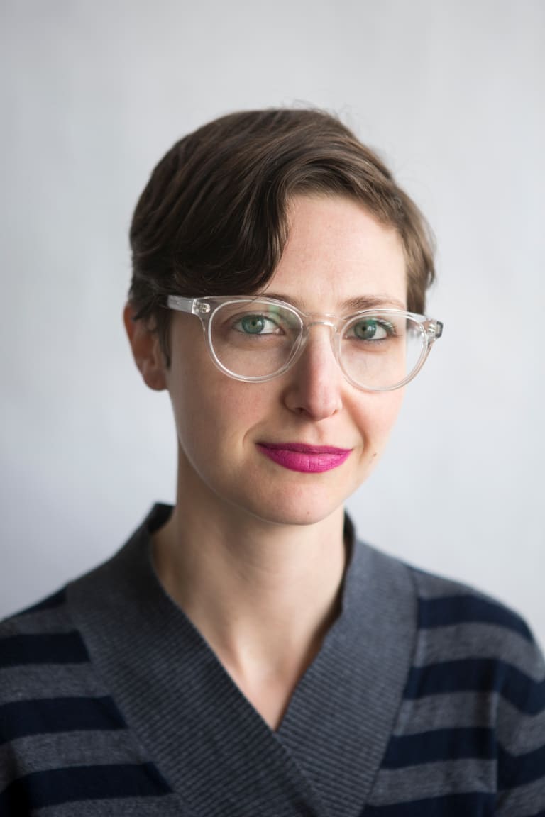 Photo of a woman with short hair wearing clear-framed glasses