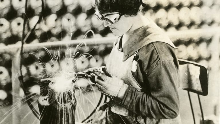 A woman welds while in a factory.