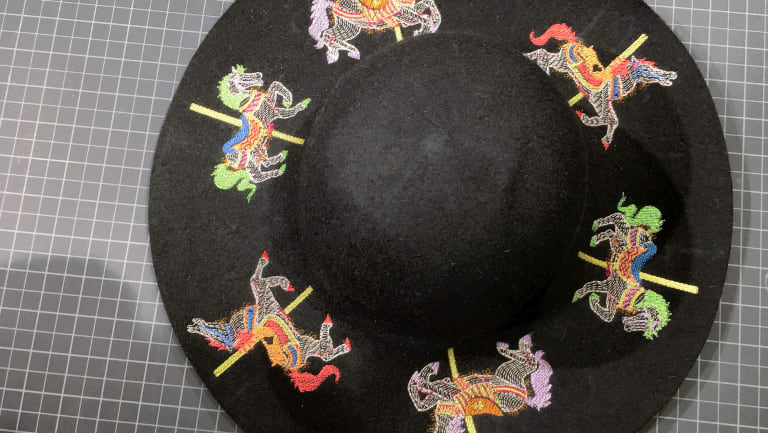 Hat with colorful embroidered carousel horses around the brim.
