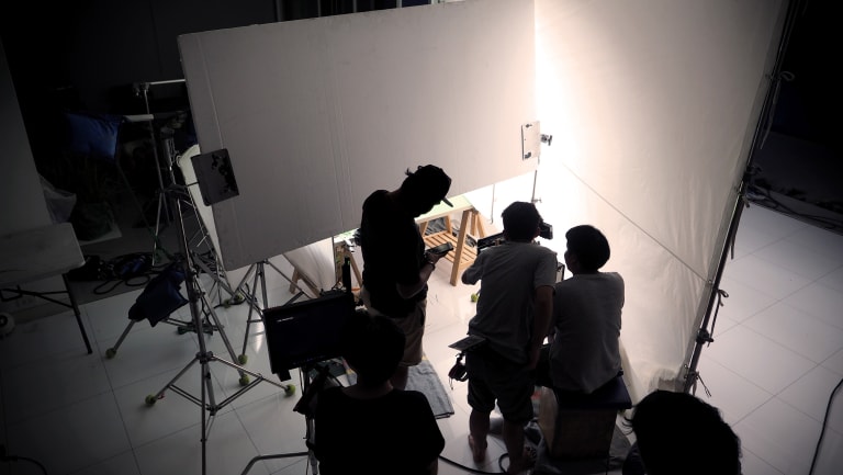 A photograph of three people in a photo studio