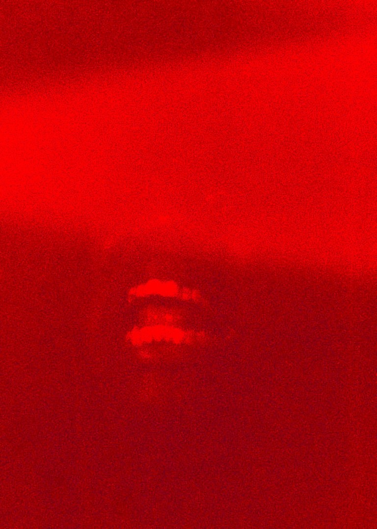 A red photograph of a person screaming