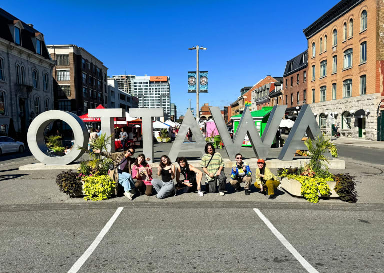 A group of students pose outside an Ottawa sign in Ottawa, Canada. 