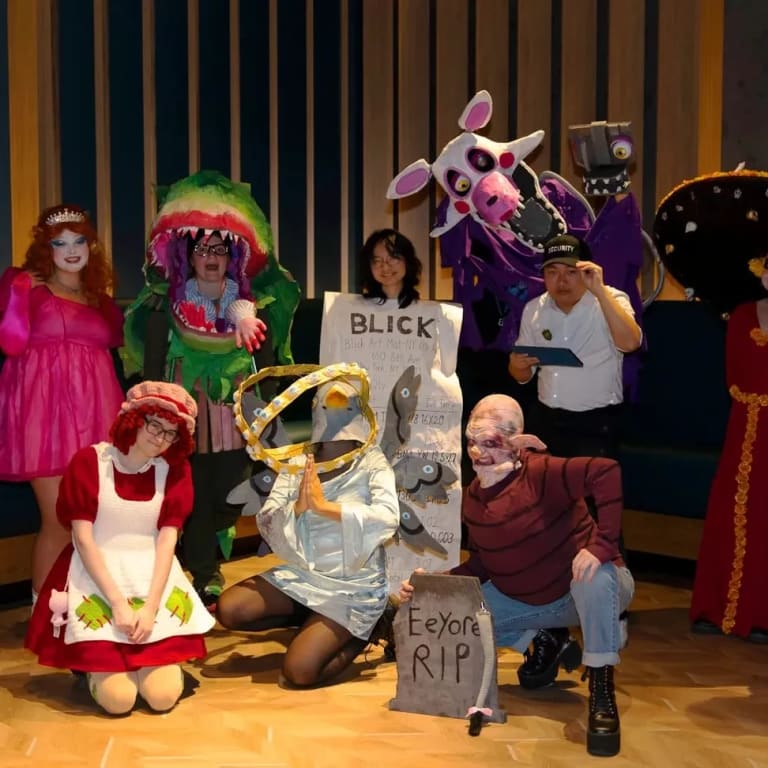 A group of students pose for the camera, all dressed in various Halloween costumes.