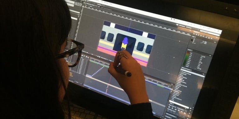 A person edits an animation in photoshop on a touch screen