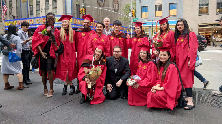 The graduating MPSDP class of 2019 stands on the street with the Radio City Music Hall in the background.