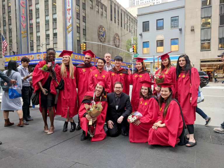 The graduating MPSDP class of 2019 stands on the street with the Radio City Music Hall in the background.