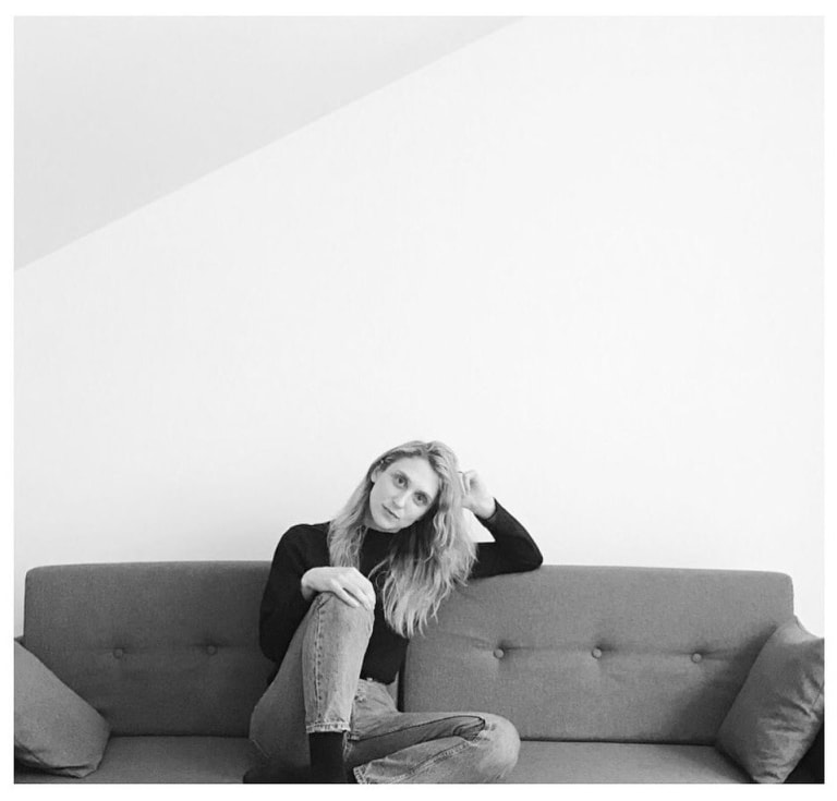 Black and white photograph of Julia Volonts sitting on a couch.