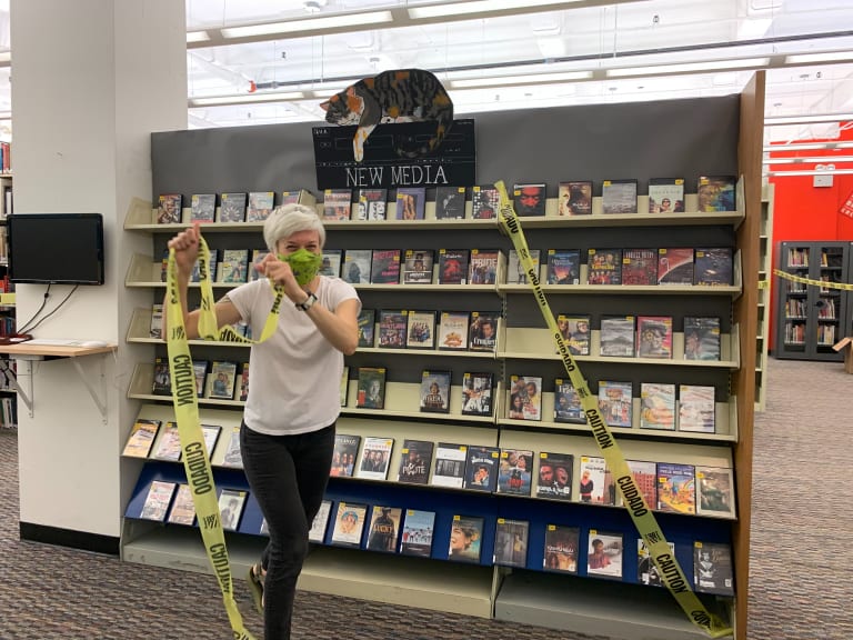 An SVA Librarian happily tears the caution tape off a display of DVDs at the SVA Library