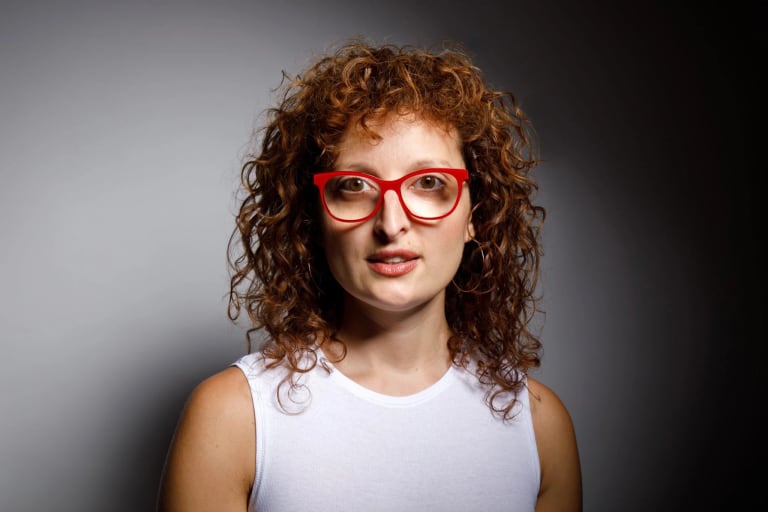 Headshot of Lucia Pietroiusti, a woman with red hair and red glasses