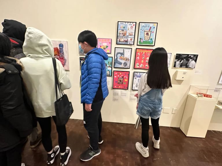 Picture of a few children looking at framed artwork at a museum exhibition.