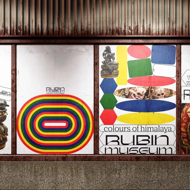 An urban display of various posters for the Rubin Museum, which includes an intricate sculpture image and multicolored geometric elements.