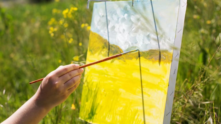 person painting in a field
