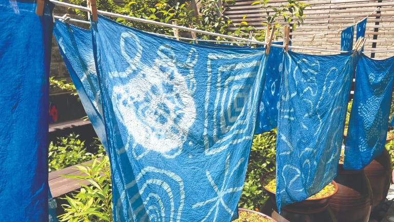 A scene of natural indigo-dyed cotton fabrics with soy resist paste drawings