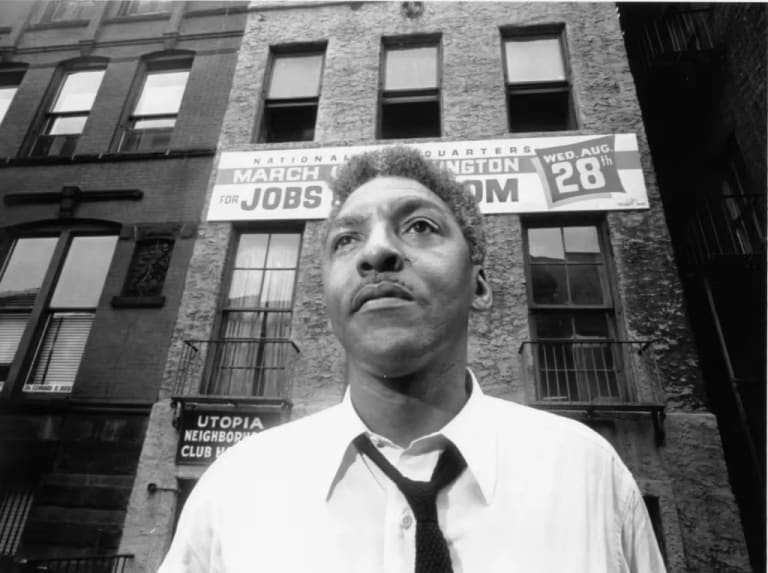 black-and-white photo of Bayard Rustin in front of the March on Washington office