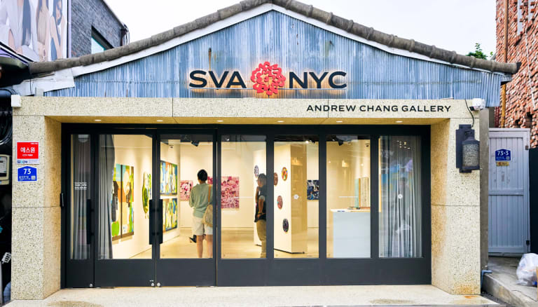 An shot of the SVA NYC Andrew Chang Gallery with people inside looking at art. 