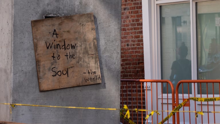 sign on wall near construction that says "a window to the soul"