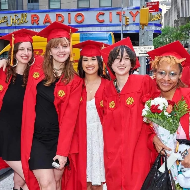 A group of graduating students posing outside Radio City Music Hall.