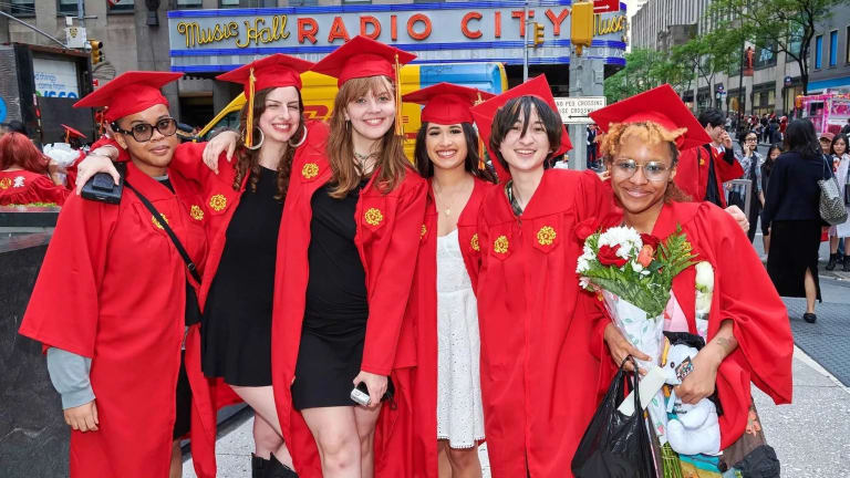 A group of graduating students posing outside Radio City Music Hall.