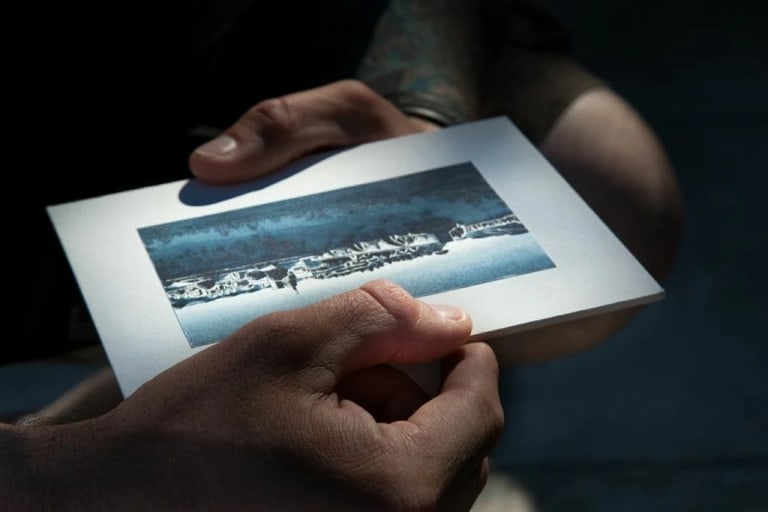 Photograph of hands holding a landscape photograph.