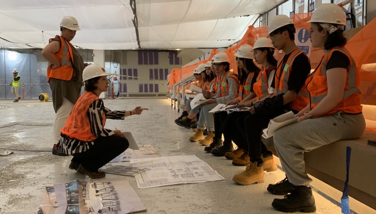 Instructor in hard hat lecturing students