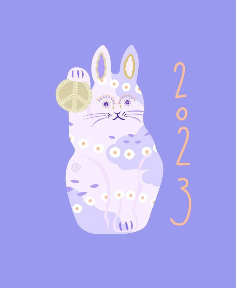 An illustration of a rabbit in the shape of a lucky cat holding a peace sign. The rabbit is light purple and the background is a darker purple