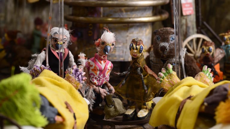 A stop motion still of bird puppets gathered around together