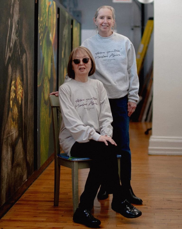 A photo of two women in matching sweaters that read "Follow your bliss"