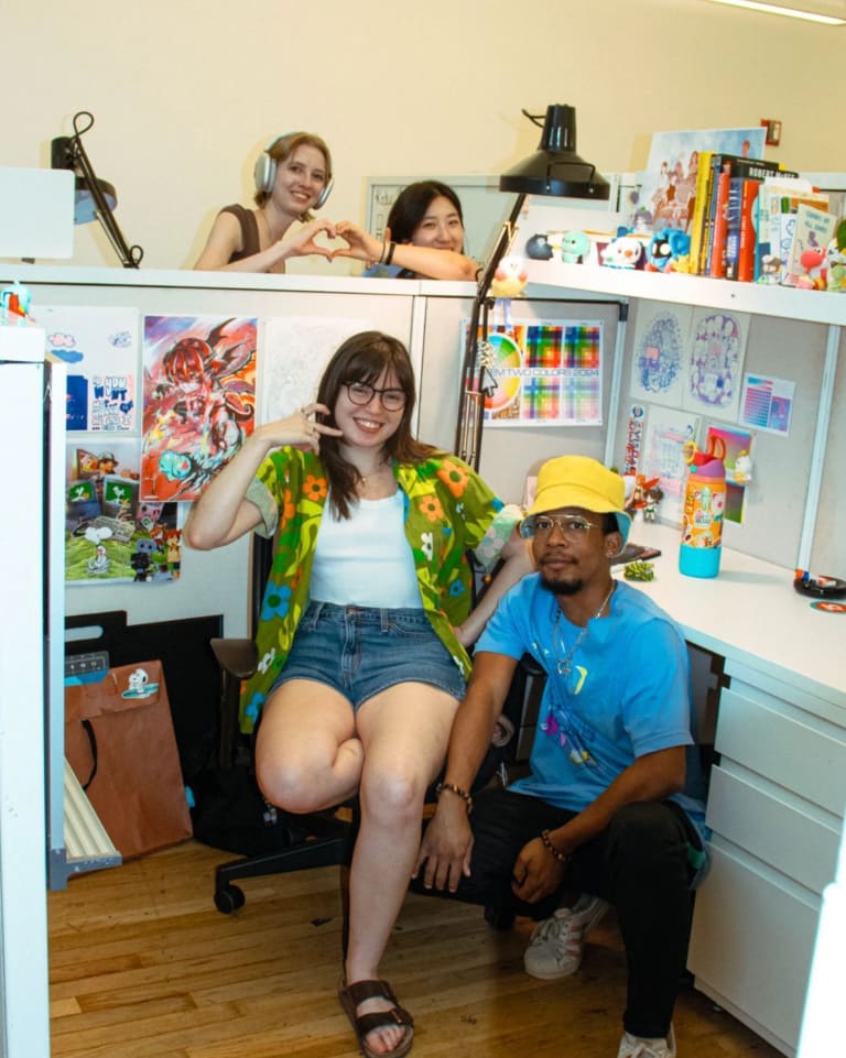 a group of students pose in their studio spaces together