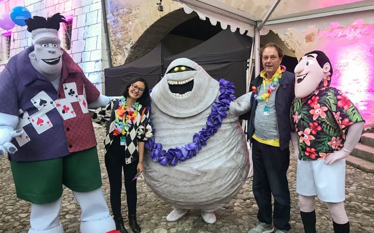 A photo of faculty and Director of Operations in MFA Computer Arts Hsiang Chin Moe and animator Bill Plympton celebrating with Sony Animation at the <em>Hotel Transylvania 3</em> launch.
